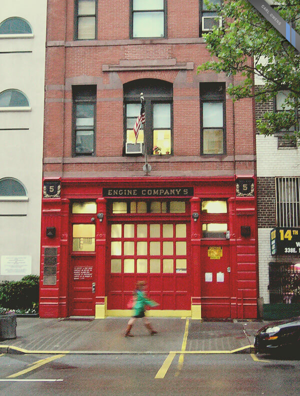 photo of a woman walking in front of a fire station in New York, NY