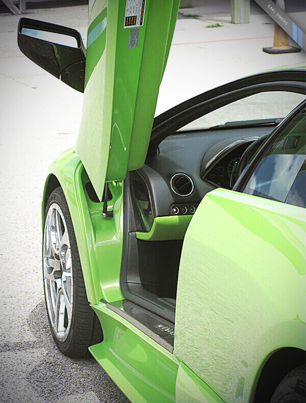 photo of a green Lamborghini with the driver-side scissor door open